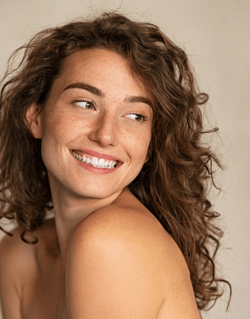 mujer sonriendo despues de un tratamiento facial